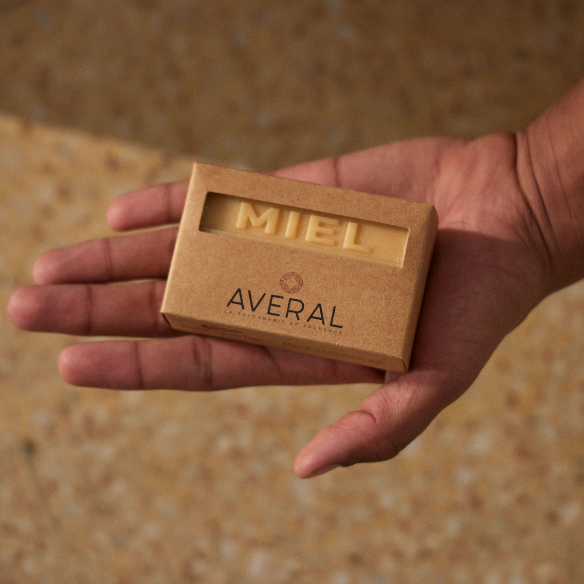 Open palm holding a boxed Averal Provence Honey French bar soap in a kraft box