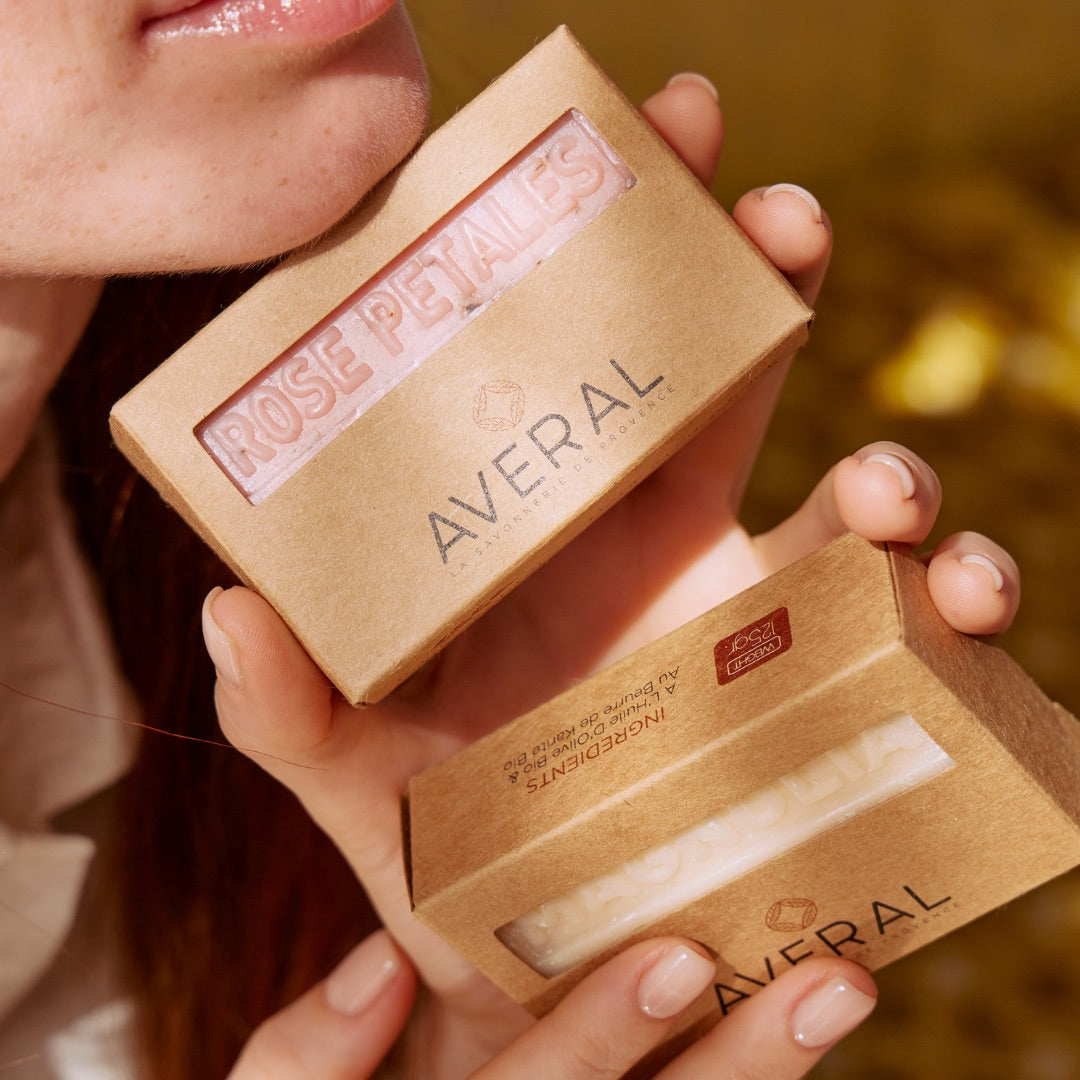 Hands holding two boxed Averal Provence Rose Petals French bar soaps in kraft boxes