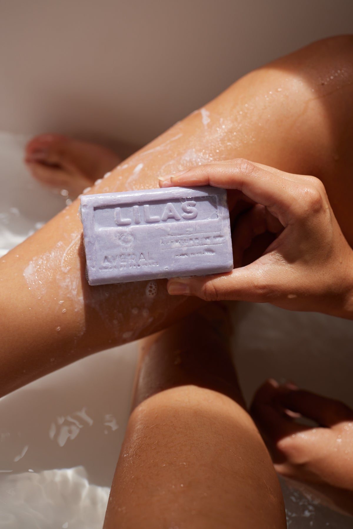 Averal Provence Lilac French bar soap lathered on a leg in the bath