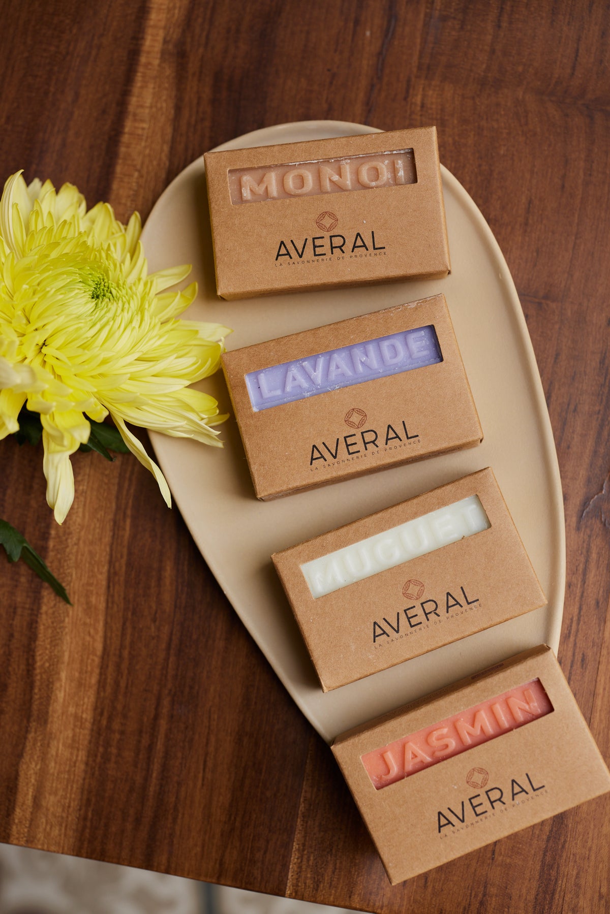 Averal Provence Floral Moisturizing Gift Set: Monoï, Lavender, Lily of the Valley and Jasmin French bar soaps on a plate with a yellow flower