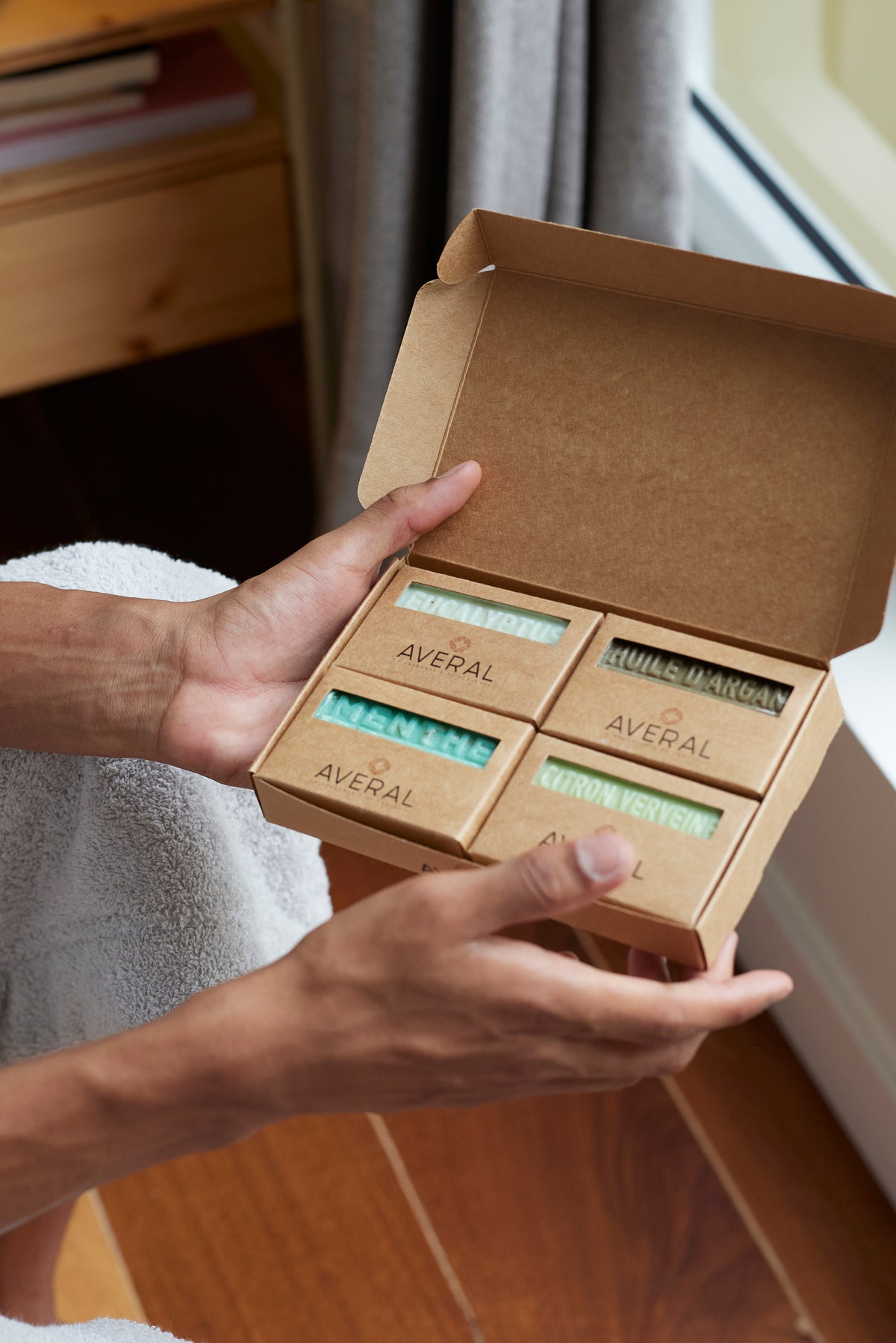 Hands holding the Averal Provence Gifts for Him box: Eucalyptus, Argan Oil, Mint Exfoliating and Lemon Verbena French bar soaps
