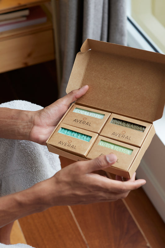 Hands holding the Averal Provence Gifts for Him box: Eucalyptus, Argan Oil, Mint Exfoliating and Lemon Verbena French bar soaps