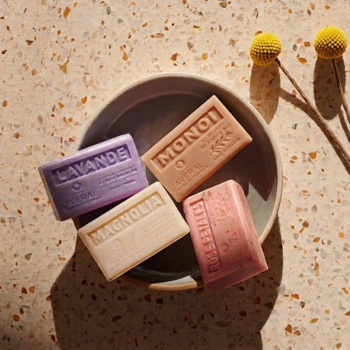 Averal Provence Lavender, Monoi, Magnolia and Rose Petals French bar soaps in a ceramic bowl on terrazzo