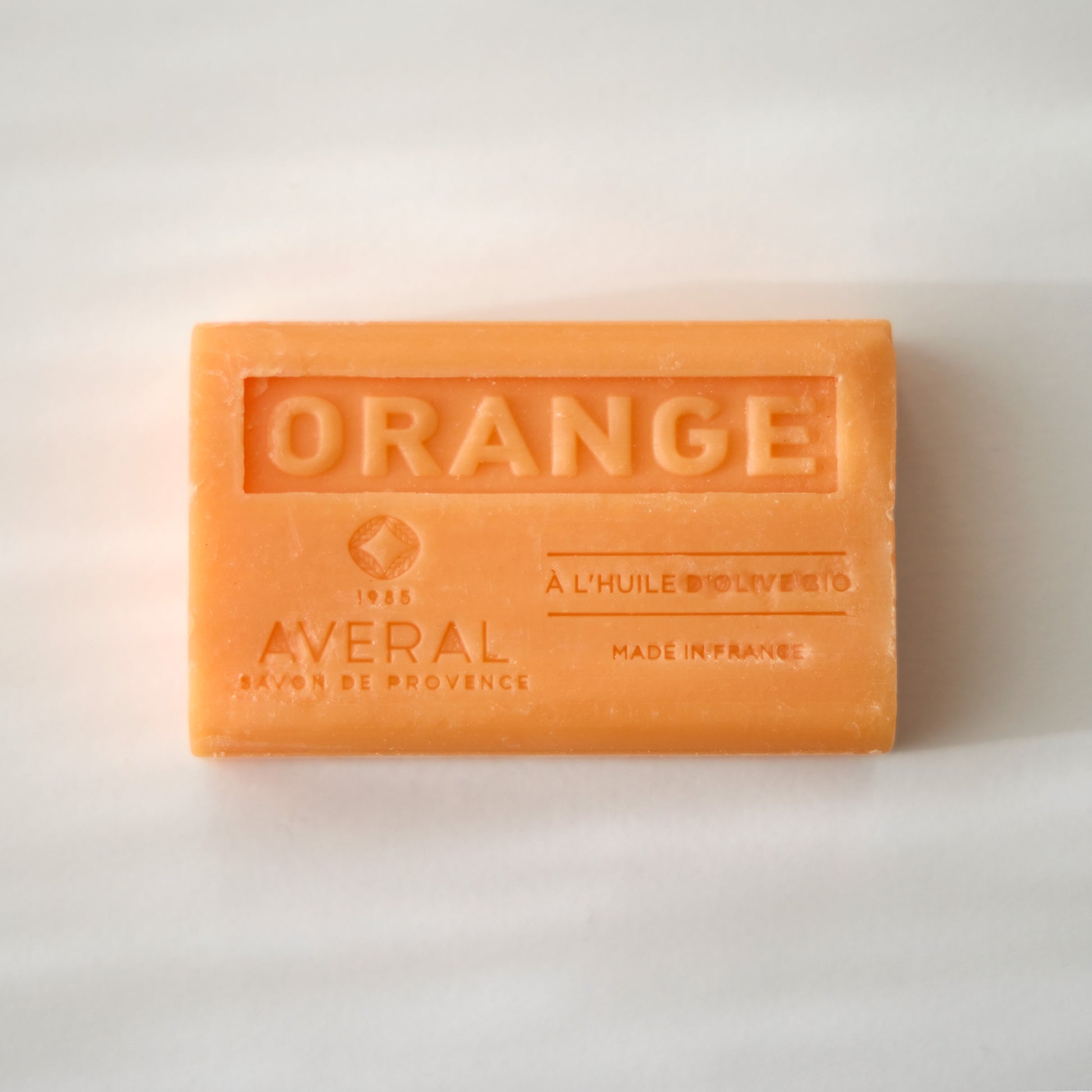 Orange bar of soap with 'Averal' branding on a light background